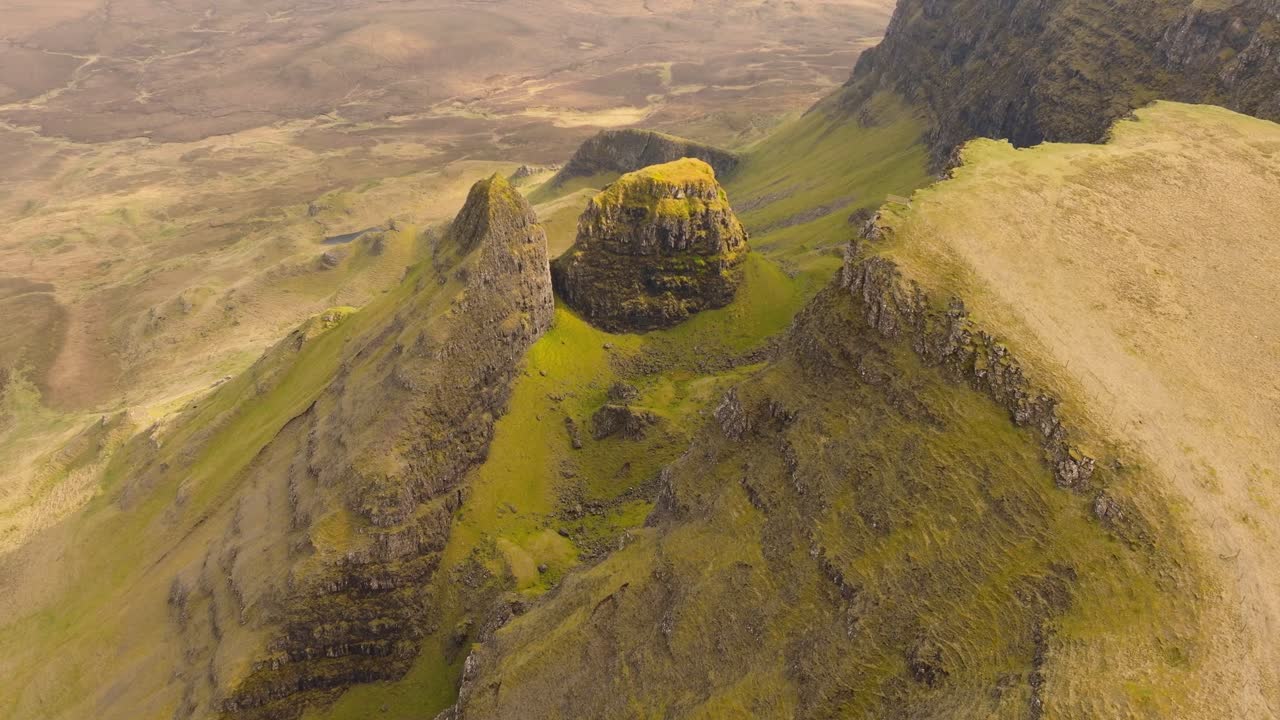 Rekaman drone udara lanskap pegunungan yang dramatis di Isle of Skye, Skotlandia. Pemandangan panorama luas puncak-puncak megah, lembah-lembah hijau, dan alam liar.