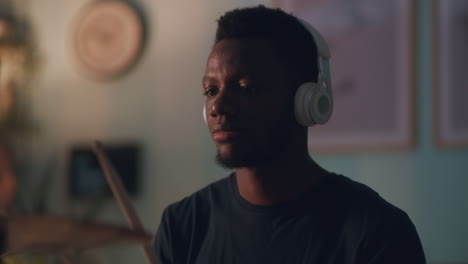 african american guy playing drums in studio close up shot of black guy playing drums with drumsticks during in music studio