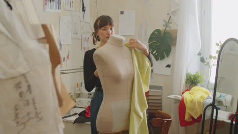 female dressmaker attaching fabric to dress form