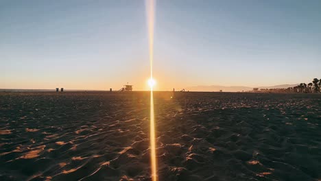 puesta de sol en la playa con el puesto de socorristas