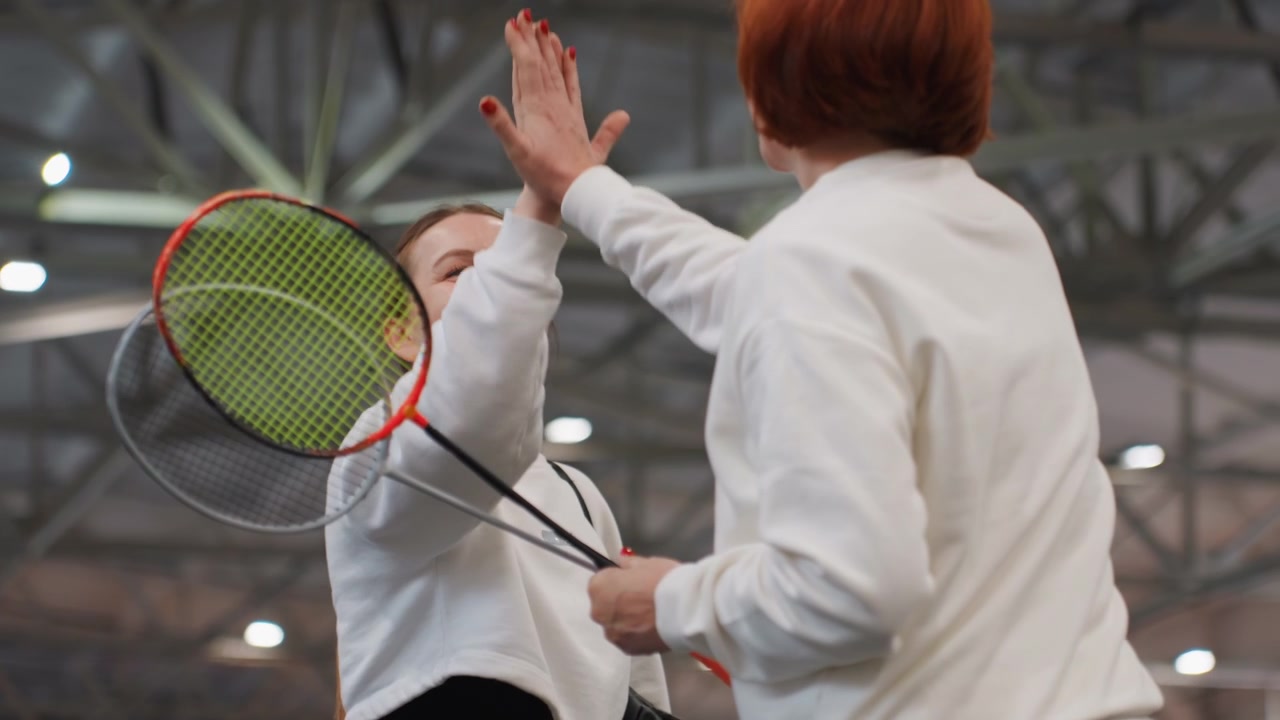 Vennlig kampstart. Deltakere utveksler varme og vennlige hilsener før kampstart. Sportslige bekjentskaper utveksler muntre og varme hilsener før tennis-kampen begynner