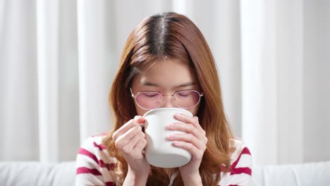추운 날 긴장을 풀기 위해 뜨거운 차 한 잔을 마시는 아시아 젊은 여성