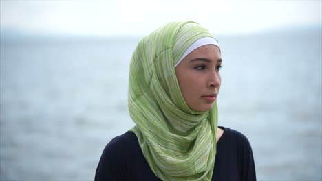 young woman in hijab by the water