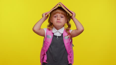 Cheerful-cute-happy-funny-schoolgirl-kid-with-book-on-head,-making-playful-silly-facial-expressions