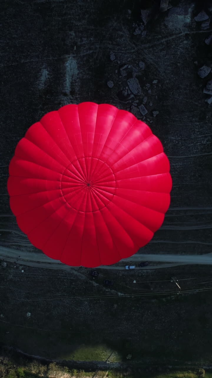 Mongolfiera rossa sopra un paesaggio