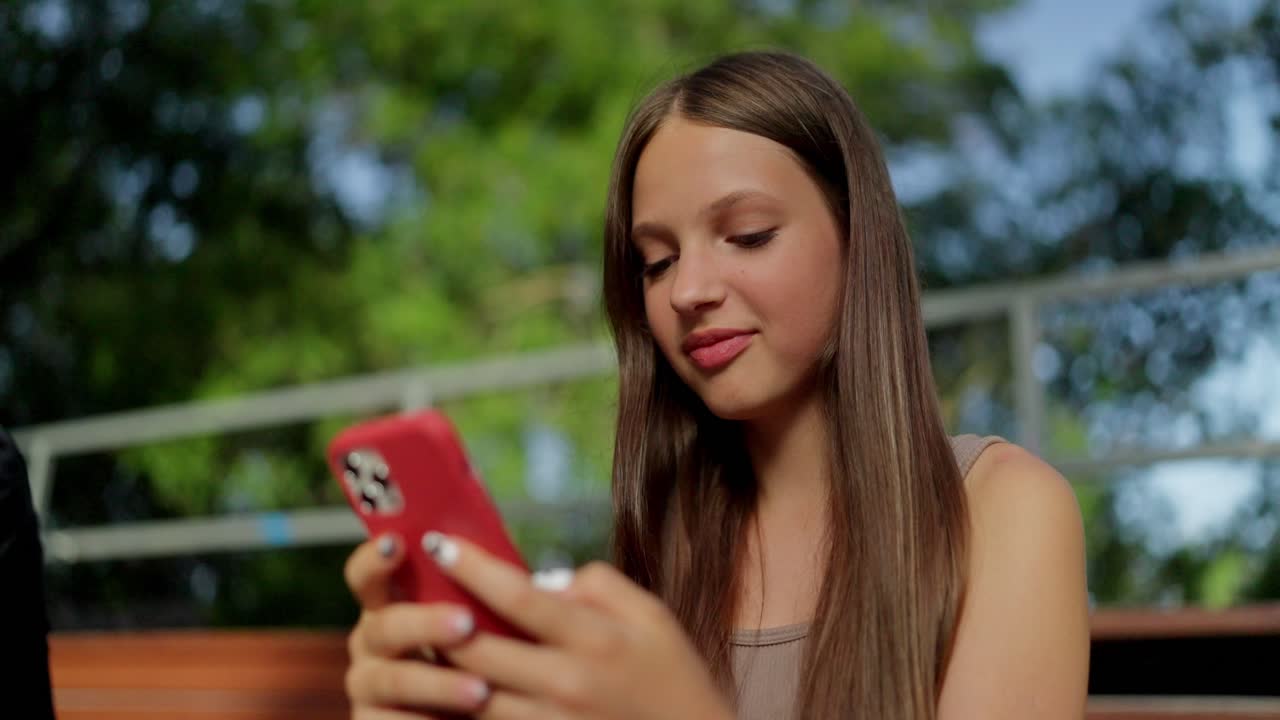 Giovane donna che sorride e usa il suo telefono.