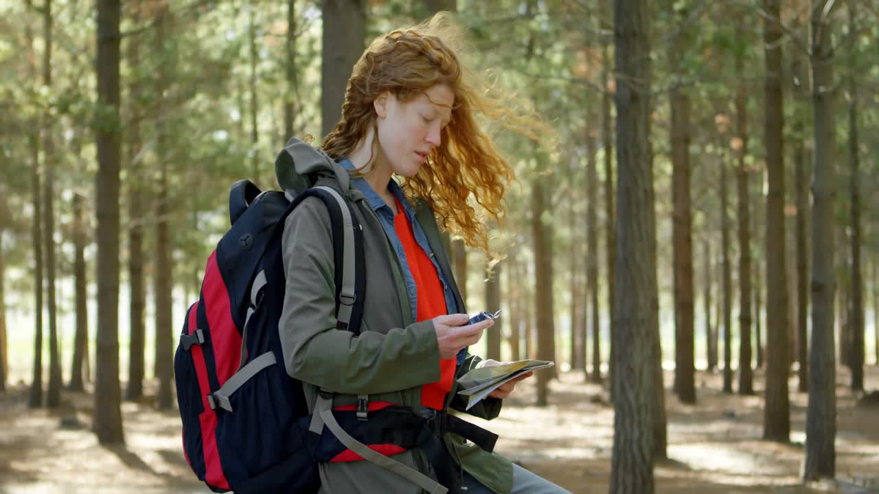 Woman using mobile phone in he forest 4k