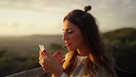 slow motion shot of a model touching up her makeup in between shoots during sunset