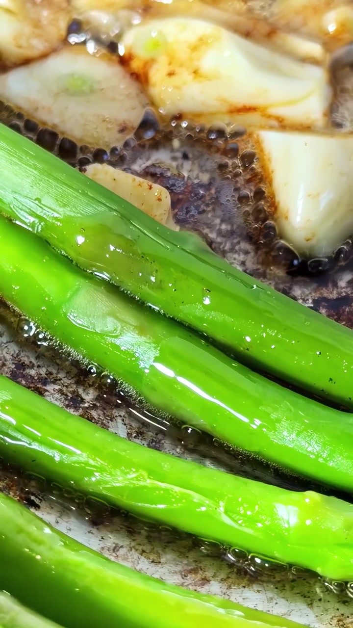 Scallops searing in bubbling dark butter with asparagus in a hot pan, extreme close up detail