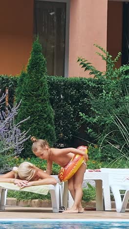 people sitting by the poolside of a resort swimming pool during summer holiday