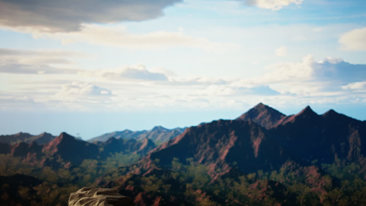 어색한 여행자는 강한 바람에 의해 산꼭대기에 균형을 잃습니다.