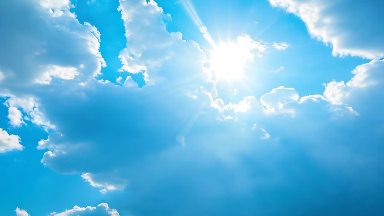 Un video sereno cattura una visuale dal basso dell'angolo del sole che splende attraverso soffici nuvole in un cielo blu brillante