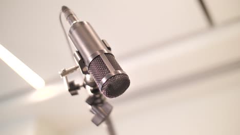 close up on hand adjusting microphone in professional recording studio