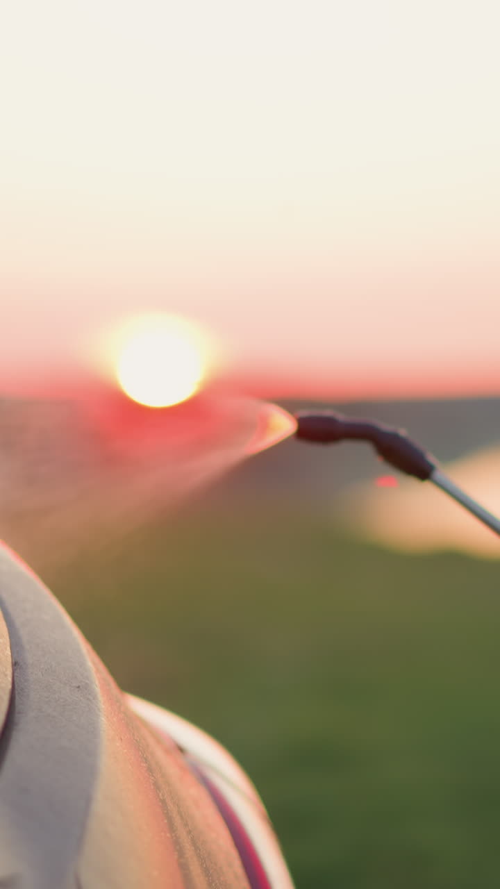 아이는 강변에서 물 으로 차를 청소합니다. 아이의 손은 어두운 호수변에서 자동차를 기 위해 스프레이어를 들고 있습니다. 가족 차량을 돌보고 있습니다.