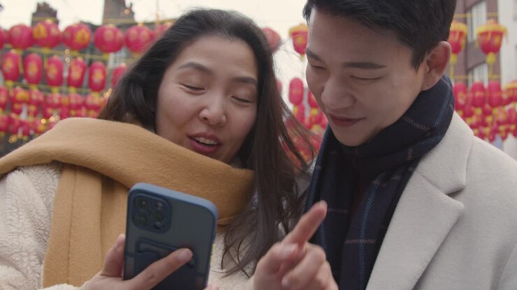Young Asian Couple On Holiday Posing For Selfie On Mobile Phone In Chinatown London UK 3