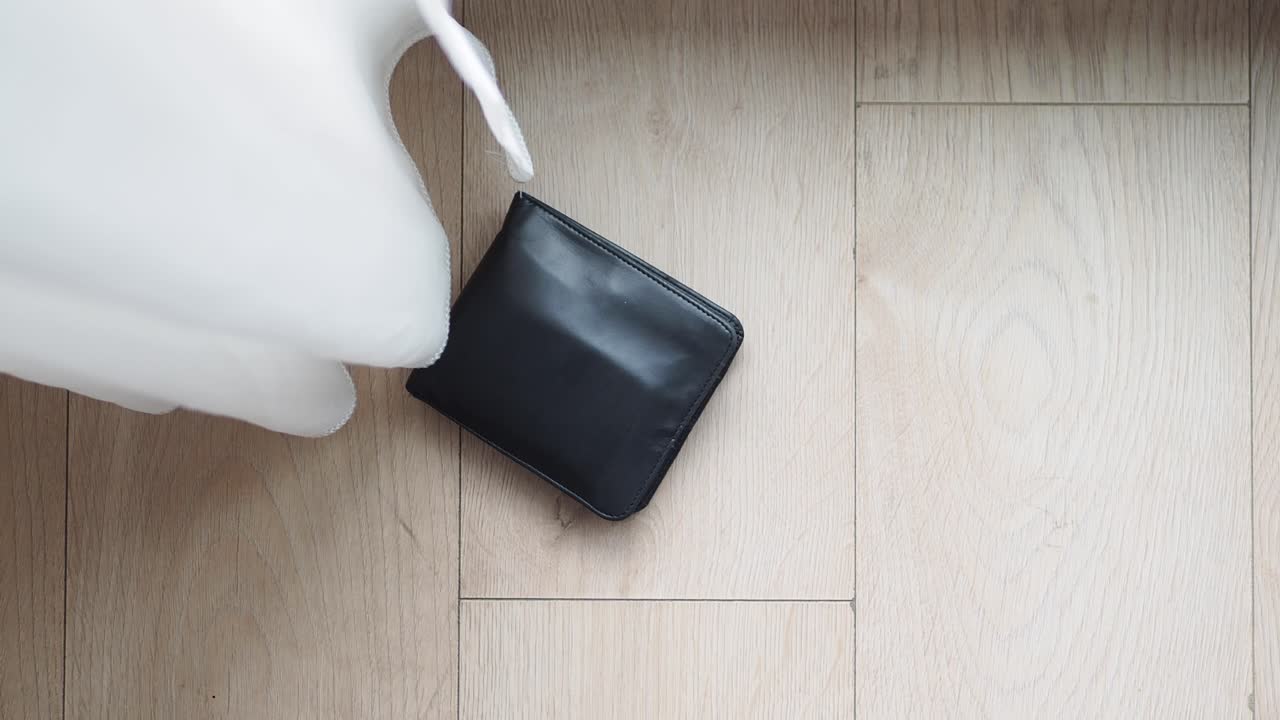 나무 바닥에 검은 가죽 지갑