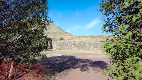 complejo piramidal de teotihuacan, contra un cielo azul intenso y una toma cautivadora de un matorral