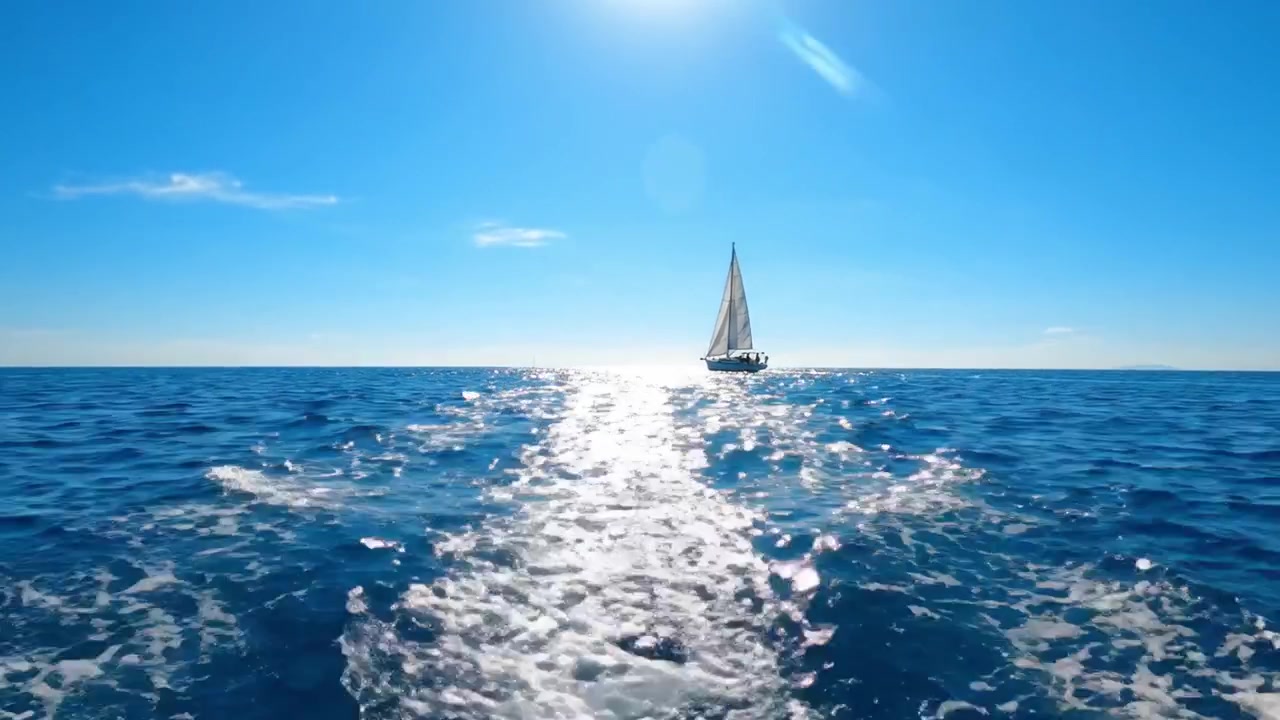 海を渡る穏やかな旅：晴れ渡る青空の下、帆船が静かな水面を進む