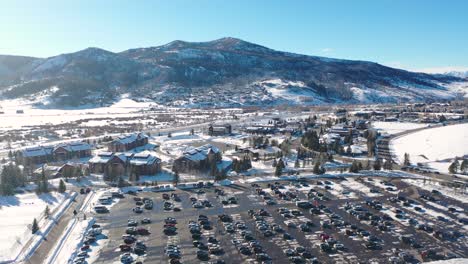 Coches-En-Plazas-De-Aparcamiento-En-La-Estación-De-Esquí-Y-Cabañas-En-La-Nieve-Durante-El-Invierno-En-Steamboat-Springs,-Colorado