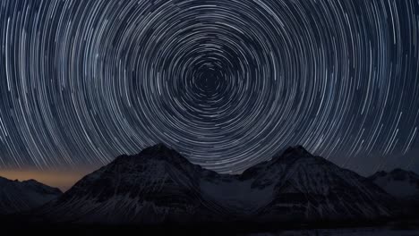 circular star trails over snow-capped mountains
