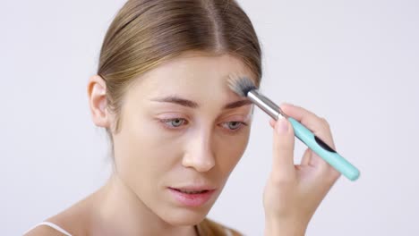 woman applying foundation with makeup brush