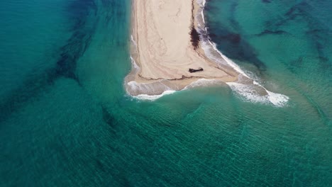 Aerial-top-view-of-sea-waves-hitting-sandy-Posidi-Beach-with-crystal-clear-water-and-sandy-coastline-in-Greece