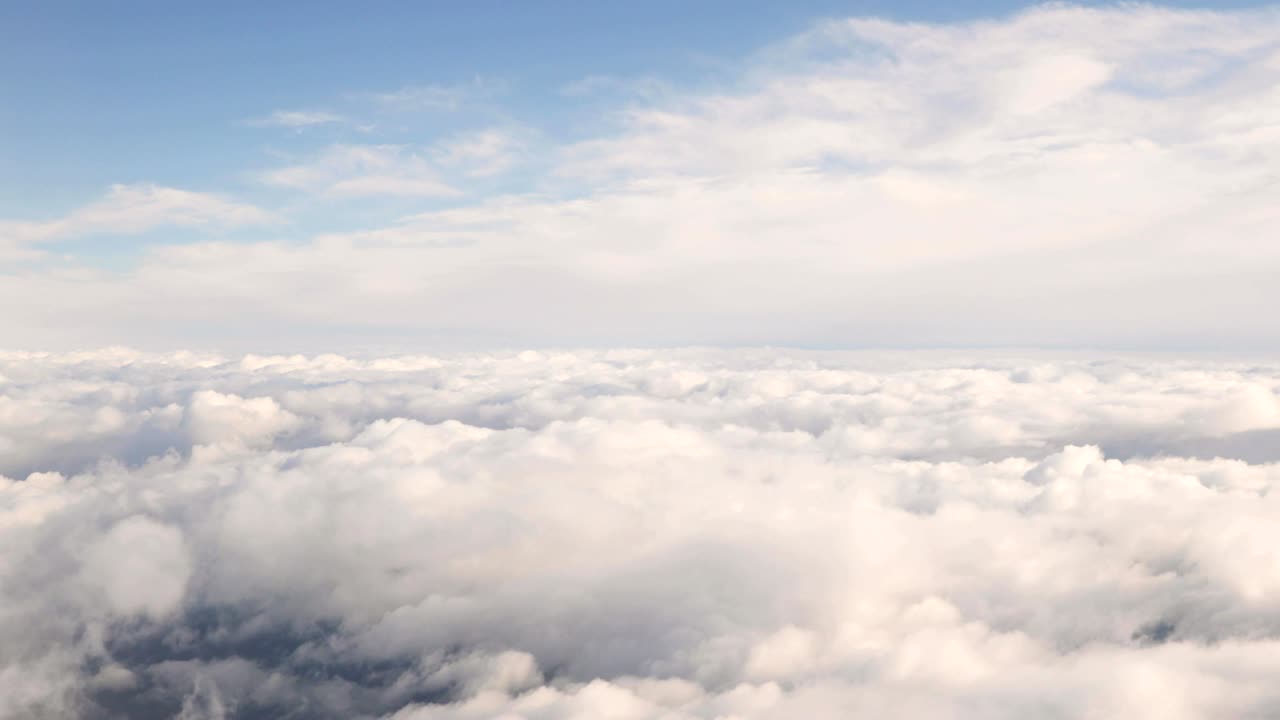 hermosa vista aérea del cielo despejado sobre nubes blancas y esponjosas desde el vuelo de altura del avión