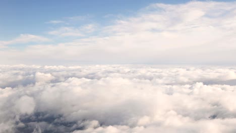hermosa vista aérea del cielo despejado sobre nubes blancas y esponjosas desde el vuelo de altura del avión