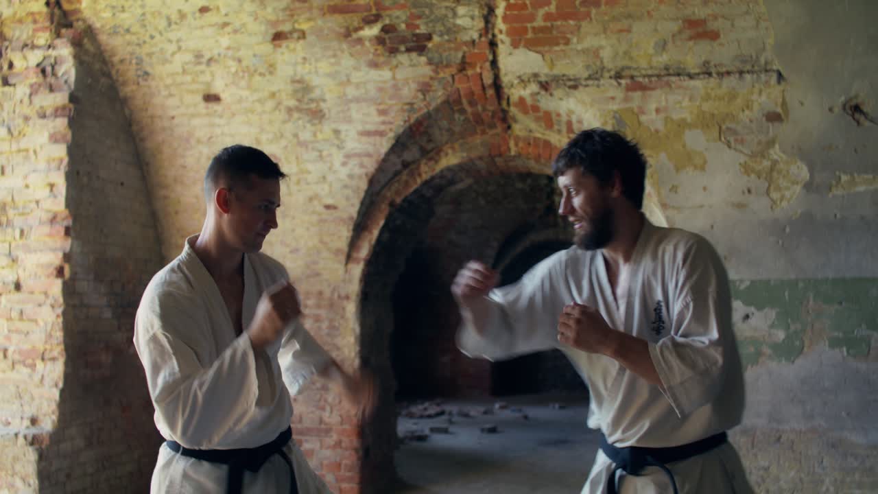 To mænd, der træner karate indendørs