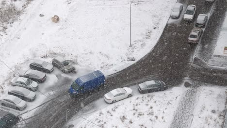 mirando por la ventana en la calle de la ciudad con coches. clima nevado