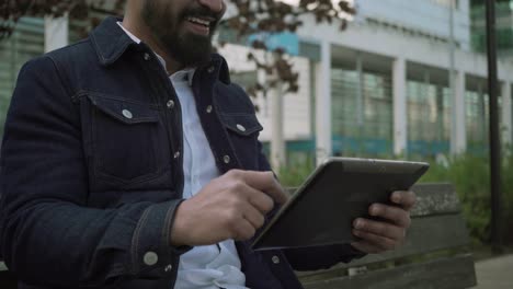 hombre feliz usando tableta digital y riendo al aire libre