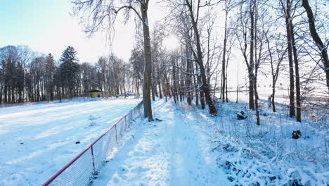 Luftflug-Entlang-Des-Grenzzauns-Eines-Schneebedeckten-Feldes