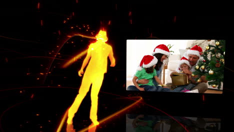 Silhouette-dancing-while-a-video-of-a-family-at-Christmas-time-appears-to-the-right