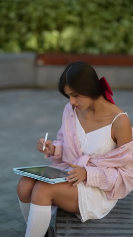 adolescente dibujando en una tableta en un parque