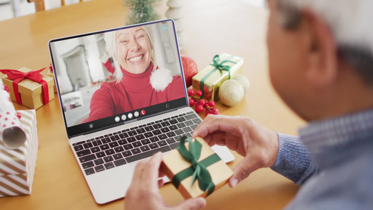 산타 모자를 입은 두 인종 남성의 애니메이션 노트북에서 크리스마스 여자와의 비디오 통화