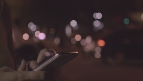 Woman-texting-on-cellphone-in-night-city-of-Hanoi-Vietnam