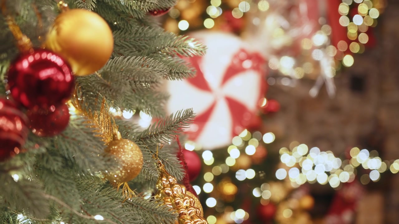 Decorazioni natalizie sull'albero di Natale: molte palline colorate, ghirlande luminose e bacche rosse