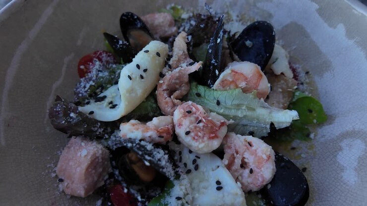 A close-up shot of a seafood salad with black sesame seeds
