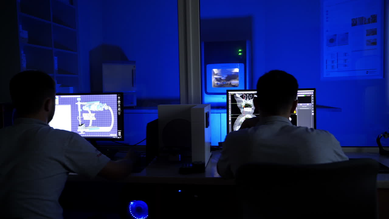Equipment at workplace of dental technician. Concentrated dental technician sitting in office, modeling of teeth crowns on computer