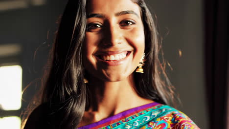 close-up portrait of a smiling indian woman in a colorful sari