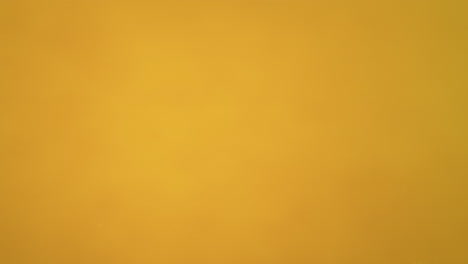 la pera cae en el agua hace burbujas y se hunde en el fondo sobre fondo amarillo, cámara lenta y macro