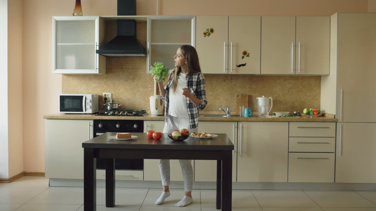 Girl and woman dancing and eating in a kitchen