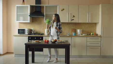 girl and woman dancing and eating in a kitchen