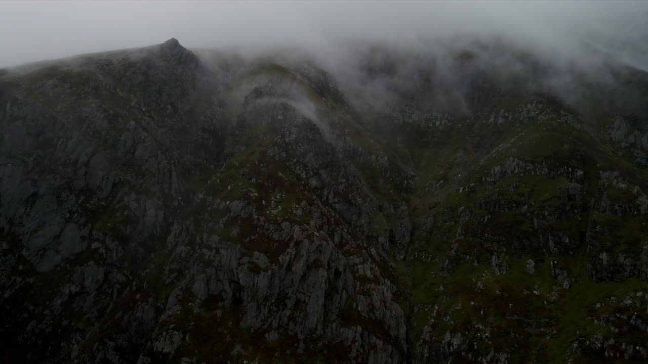 A moody drone shot of a misty Pen yr Ole Wen Mountain in Snowdonia in Wales