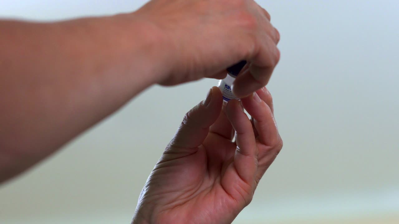 A nurse checks the state of the vaccine. Handheld.