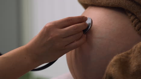 le médecin examine le ventre de la femme enceinte