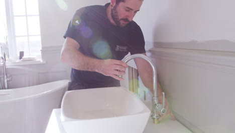 plumber positioning basin taps in new bathroom