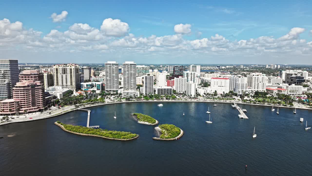 Push in drone shot of West Palm Beach marina, harbor and cityscape with white yachts during the day in Florida, USA