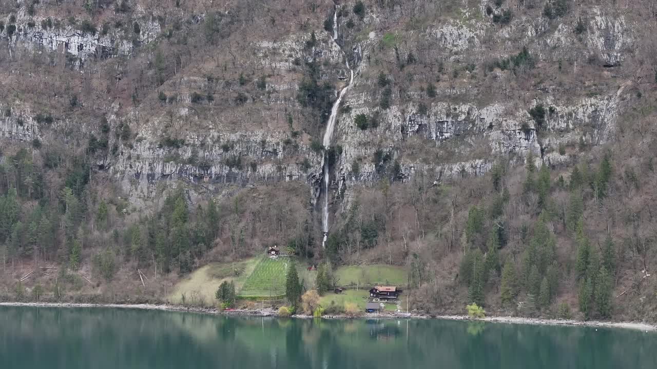 la encantadora montaña de quinten y la majestuosa cascada, con vistas a las aguas serenas del río walensee en este cautivador metraje de avión no tripulado