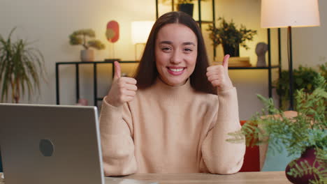 happy caucasian young woman looking approvingly at camera show thumb up like positive sign good news